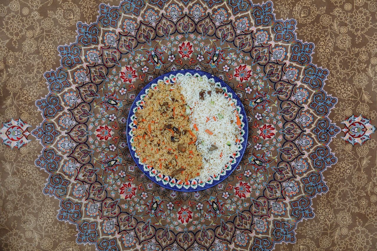 Top view of a delicious traditional rice dish served on an intricately designed Persian carpet.